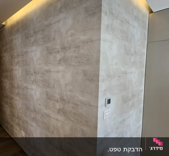 קיר עם טפט אפור ותאורה נסתרת